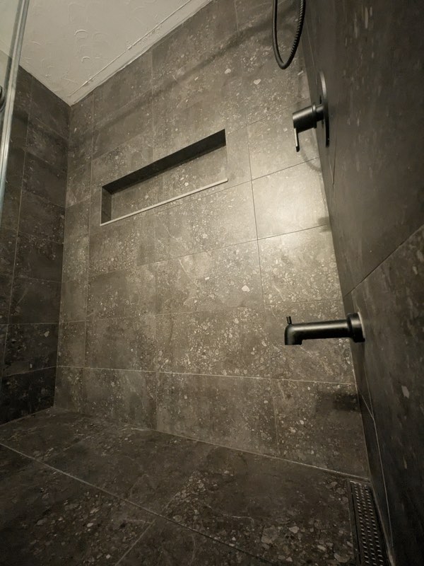 Tiled walk-in shower with matte black fixtures